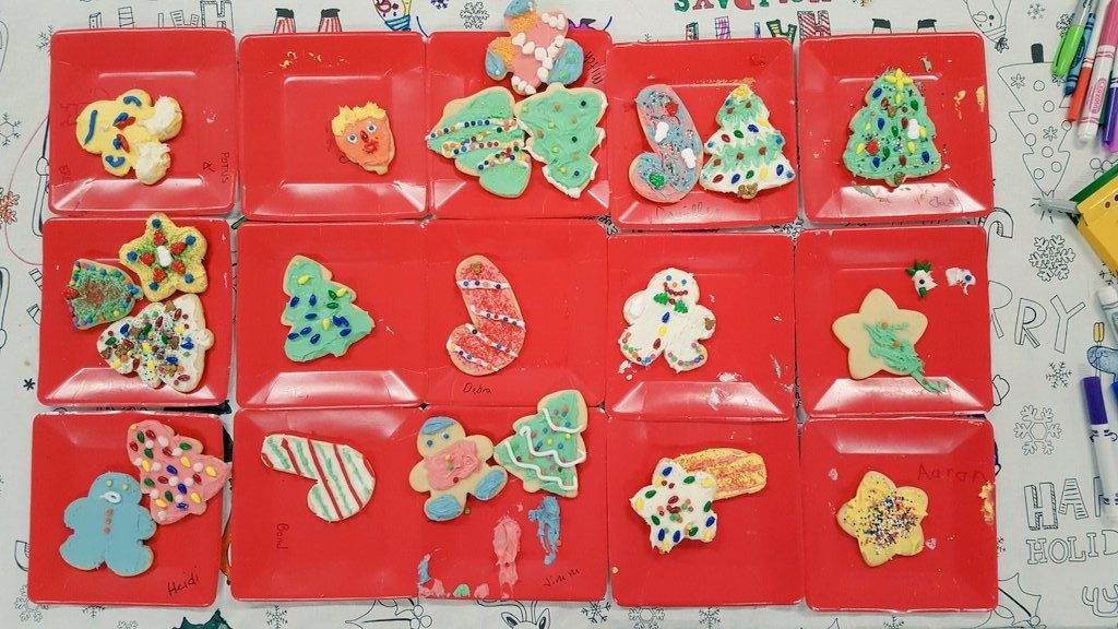 Decorated Christmas cookies on red square plates.