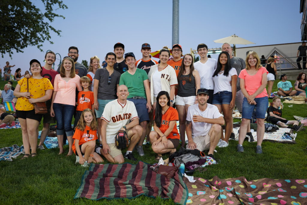 Group photo of Hill Engineering employees and their families at a baseball game.