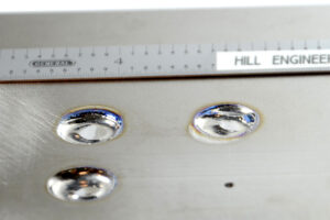 Three x-ray diffraction measurement sites on a metallic specimen. A ruler is shown for scale.