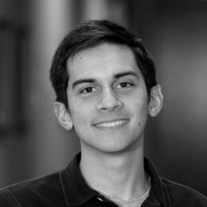 A black and white portrait of Robby wearing a black polo.