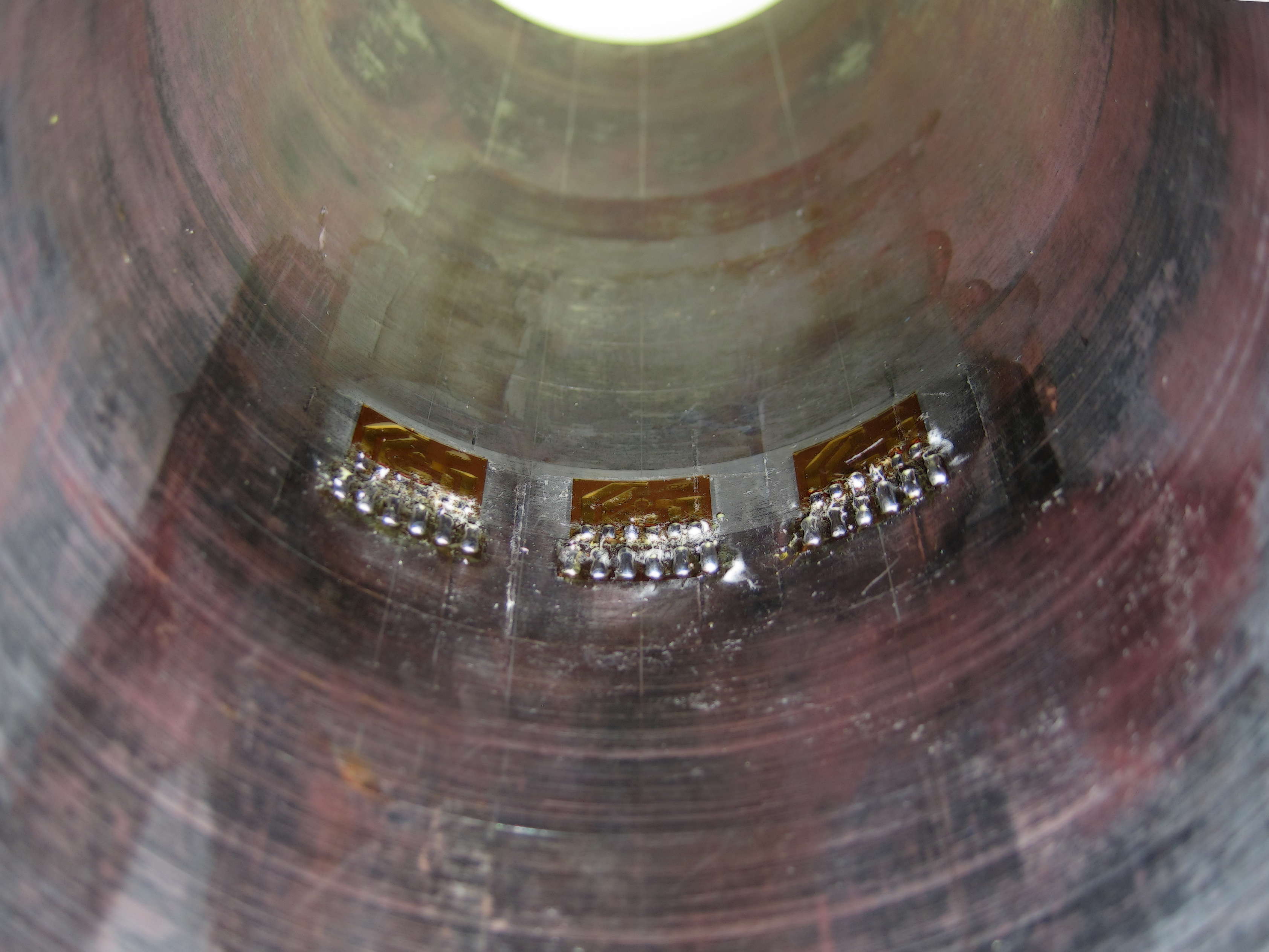 Three rosette strain gages in a row inside of a welded steel pipe.