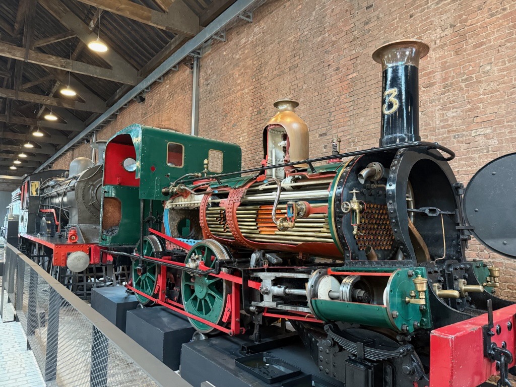 A steam locomotive with a cut in its side to see the inner workings.